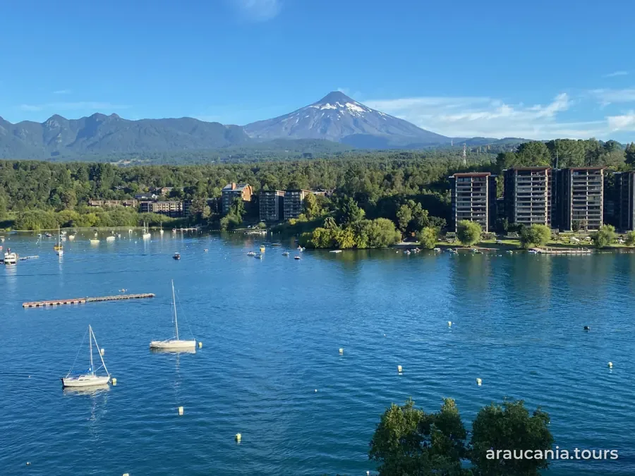 Lago con veleros y un volcán nevado al fondo