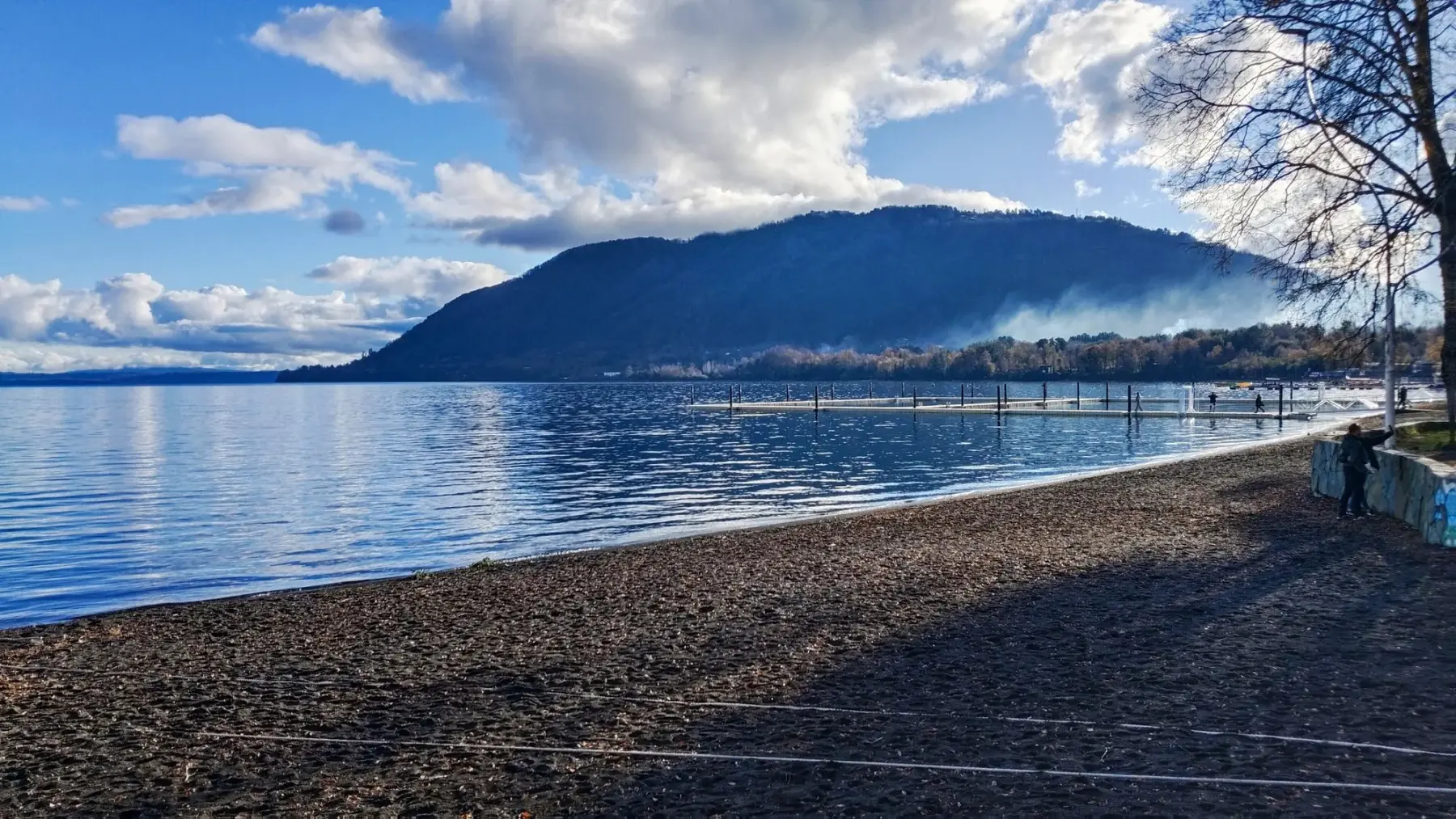 Playa Grande de Licán Ray junto al lago Calafquén, con muelle y cerros boscosos al fondo